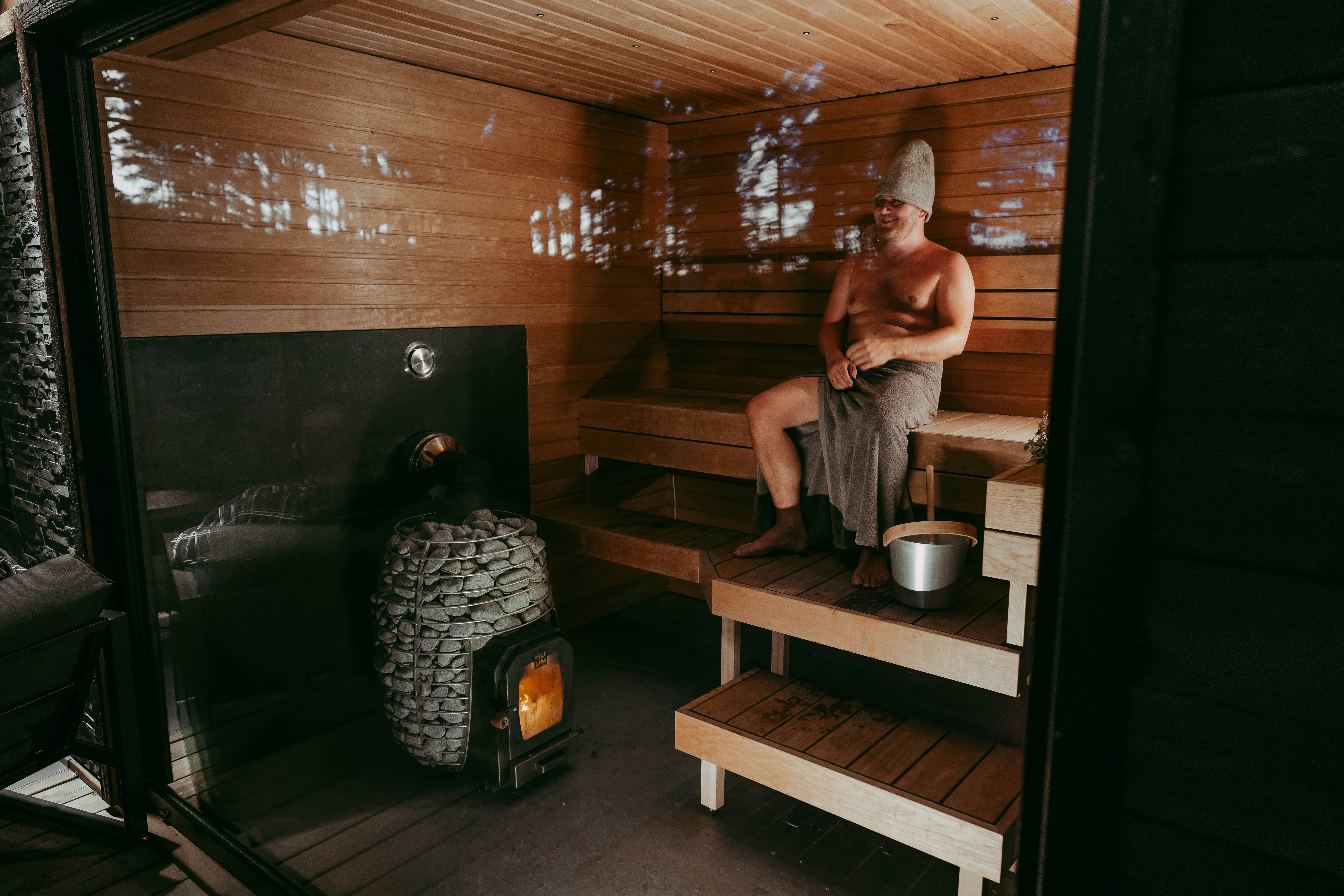 Man relaxing in sauna with panoramic window
